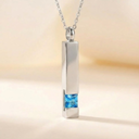 Silver pendant with a blue gemstone on a blurred background