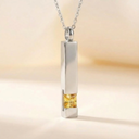 Silver pendant with a yellow gemstone on a blurred background