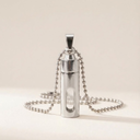 Silver necklace with a cylindrical pendant on a beige background