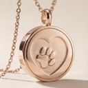 Rose gold heart-shaped pendant with paw print design on a beige background