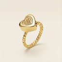 Gold heart-shaped ring on a beige background