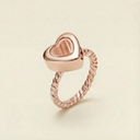 Rose gold heart-shaped ring on a beige background