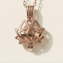 Rose gold lotus flower pendant on a beige background