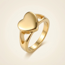 Gold heart-shaped ring on a light beige background