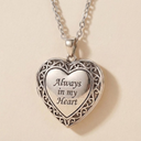Silver heart-shaped pendant necklace with 'Always in my Heart' engraving on a beige background