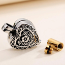Heart-shaped metal object with intricate design on a beige background