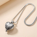 Silver heart-shaped locket necklace on a beige background