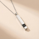 Silver necklace with a rectangular pendant on a beige background