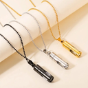 Three necklaces with different colored pendants on a beige background