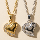 Gold and silver heart-shaped pendants with chains on a beige background