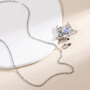 Silver necklace with a butterfly pendant on a beige surface