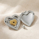 Heart-shaped locket with a gold heart inside on a beige fabric background