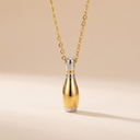 Gold and silver necklace pendant on a beige background