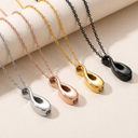 Four necklaces with different colored pendants on a light background