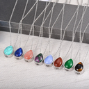 Necklaces with teardrop-shaped colorful stones on a textured surface