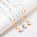 Three moon-shaped pendants on gold, silver, and rose gold chains against a white background.