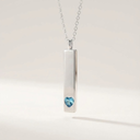 Silver necklace with a heart-shaped blue gemstone pendant on a light gray background