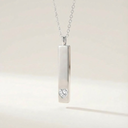 Silver necklace with a heart-shaped pendant on a light beige background