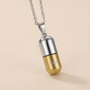 Gold and silver capsule-shaped pendant necklace on a beige background