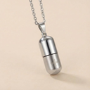 Silver cylindrical pendant necklace on a beige background