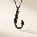 Black fishing hook pendant on a chain against a beige background