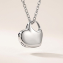 Silver heart-shaped pendant necklace on a light beige background