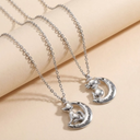 Silver cat and moon pendant necklace on a beige background