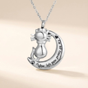 Silver cat and moon necklace with engraved text on a beige background