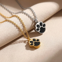 Two paw-shaped pendants on chains against a beige background