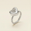 Silver heart-shaped ring on a beige background