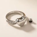 Silver ring with a heart design on a beige background