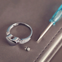 Silver ring with a small screw on a gray surface