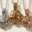 Three lotus flower pendants in gold, silver, and rose gold on a light background.