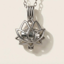 Silver lotus flower pendant on a chain against a light background