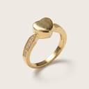 Gold ring with a heart-shaped top and small diamonds on a light background