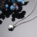 Silver necklace with a heart pendant on a gray background