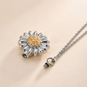 Silver and gold flower-shaped pendant on a chain against a beige background