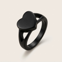 Black heart-shaped ring on a light beige background