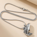 Silver fish pendant necklace on a beige background