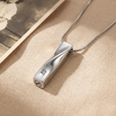 Silver pendant necklace on a beige fabric background