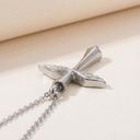 Silver cross pendant necklace on a beige fabric background