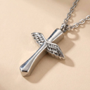 Silver cross pendant with wings on a beige background